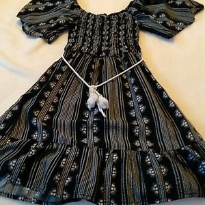 Patterned blackand white dress with white belt.